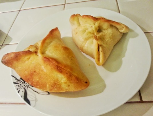 Ground beef, onion and tomato filled homemade meat pies (hand held). 